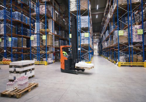 Industrial building large warehouse interior with forklift and palette with goods and shelves.
