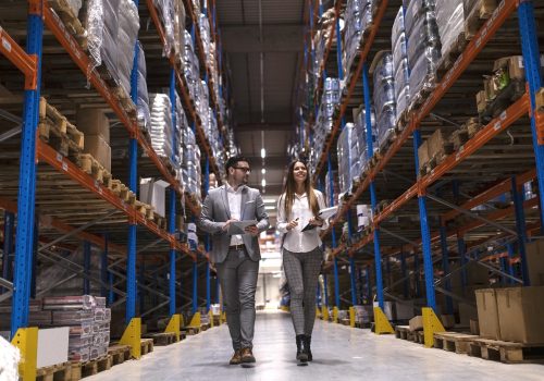 Warehouse managers walking through large distribution center.